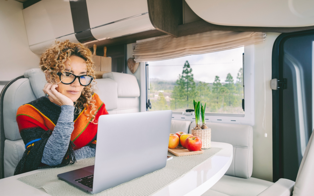 A camper van parked at a scenic overlook with an organized desk inside, symbolizing streamlined mail and document management on the road.